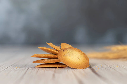 Butter pecan wafer cookies on a wooden table with a blurred background