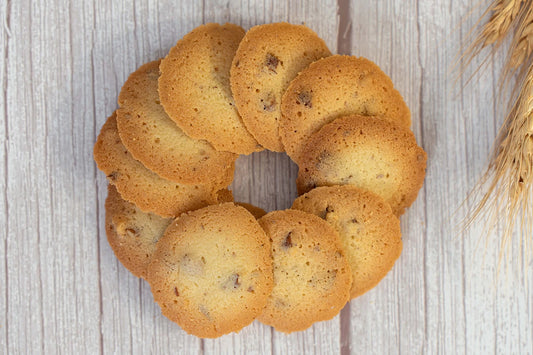 Butter pecan wafer cookies arranged in a circle on a wooden table