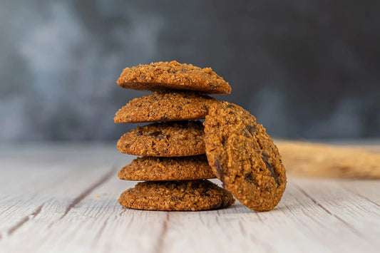 Stack of chocolate chip cookies on a wooden table with a blurred background