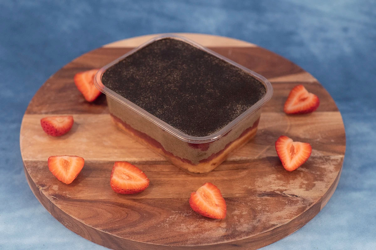 Keto strawberry hojicha box cake dessert on a wooden platter with organic strawberries.