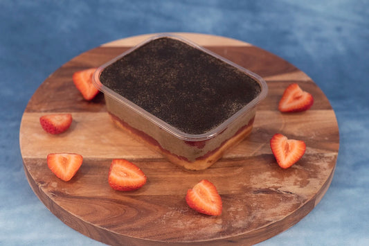 Keto strawberry hojicha box cake dessert on a wooden platter with organic strawberries.